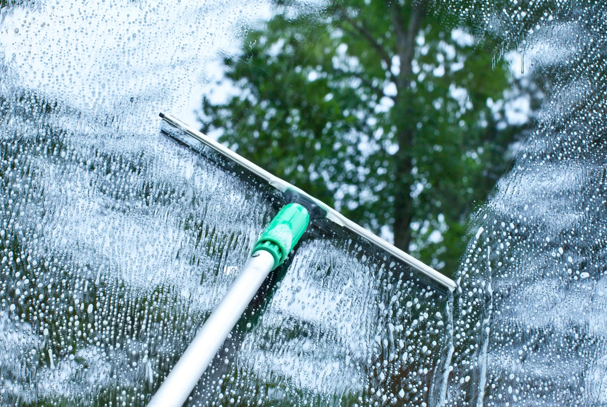 Squeegee cleaning exterior residential window glass